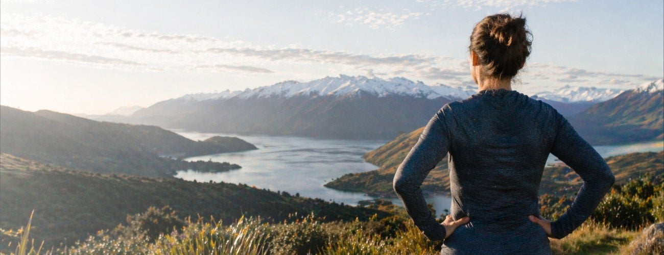 Woman looking out to nature, relief & hopeful