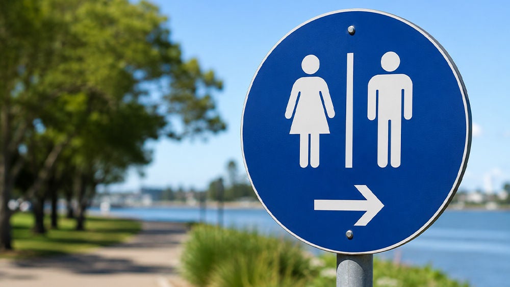 A blue circular restroom sign shows male and female symbols with an arrow pointing to the right.